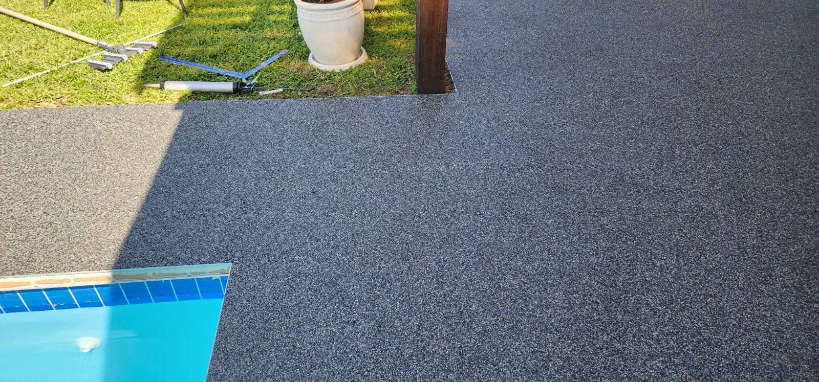 Grey and white pebbles around a pool